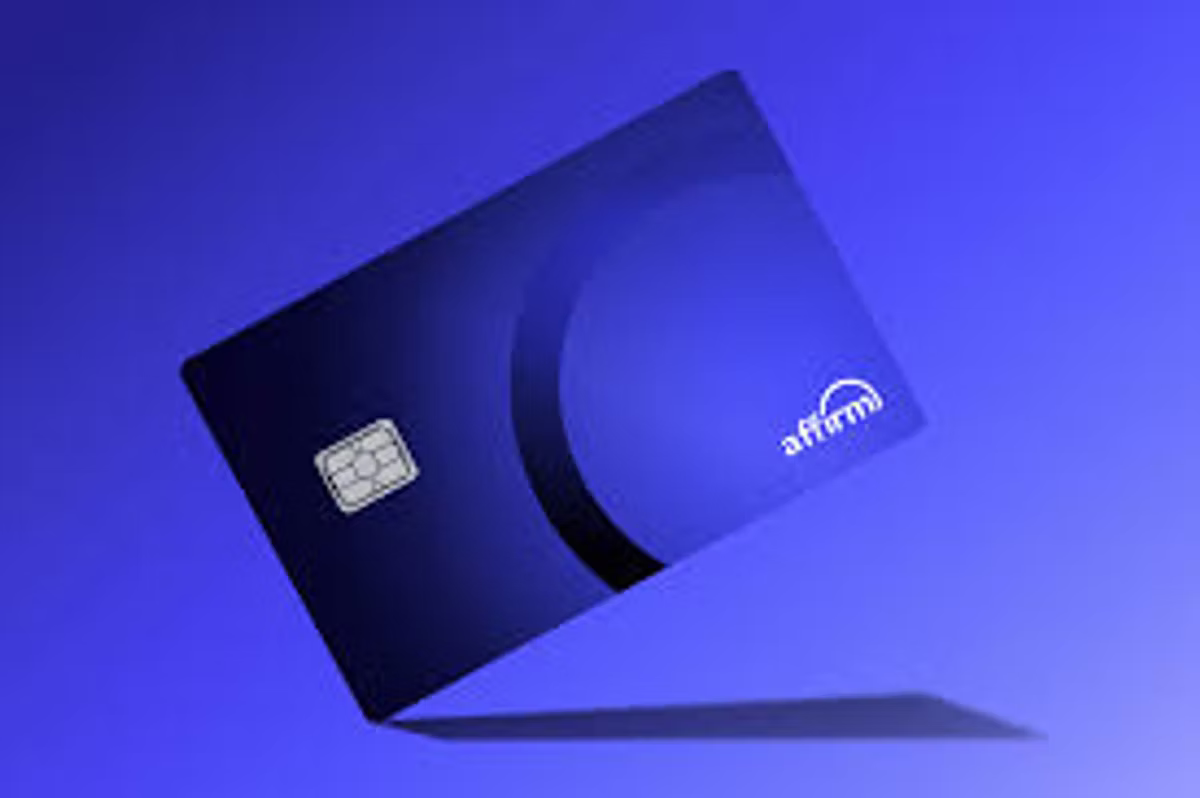 A dark blue Affirm credit card with a chip, tilted and casting a shadow on a blue background.